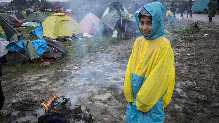 A child standing in the middle of a camp.