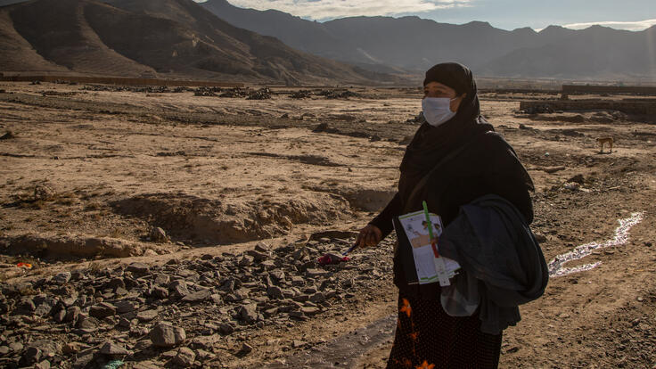 A woman walking along a dirt road.