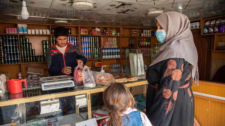 A mother and daughter purchasing food at the market.