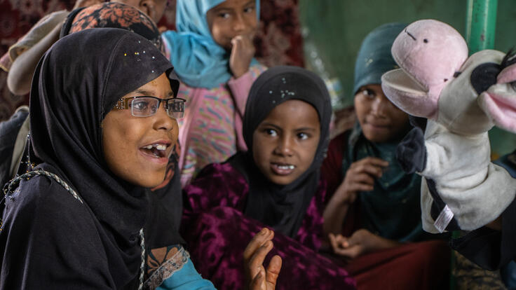 Young girls watching a puppet show.