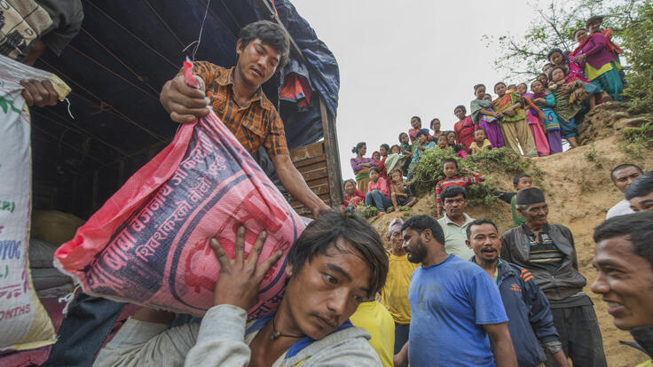 People  unloading stacks of rice.