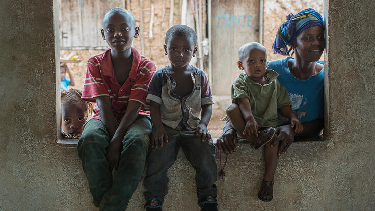 A mother and her children sitting in a windowsill.