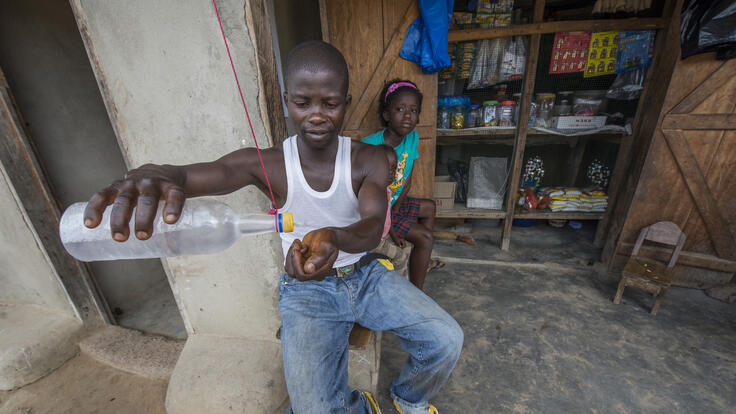 A shopkeeper washing his hands in chlorine solution in Barkedu.