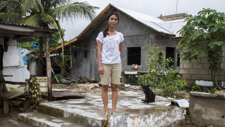 Woman standing in front of her rebuilt home.