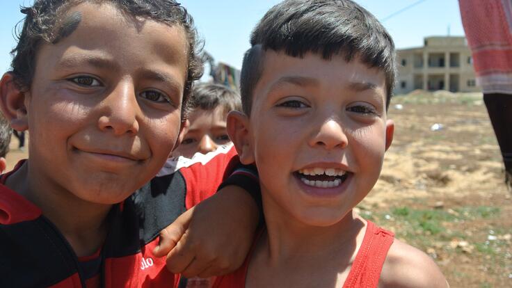 Two children smiling at the camera.