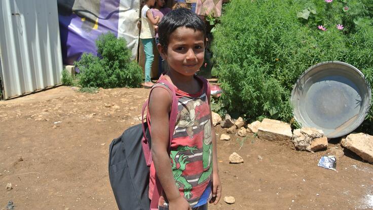 A young boy carrying a backpack.
