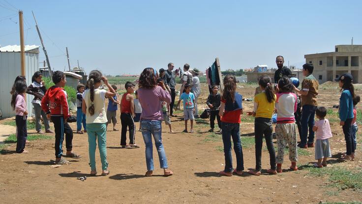 Syrian children in Ghazze playing football with IRC staff members.