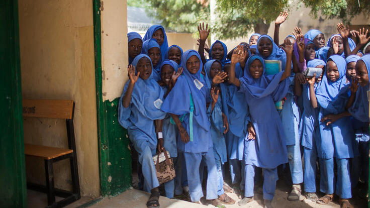 A group of women smiling and waving.