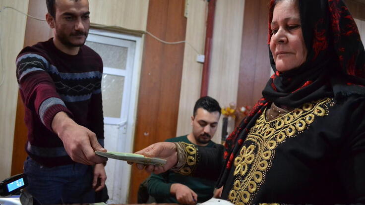 A man handing a woman paper.