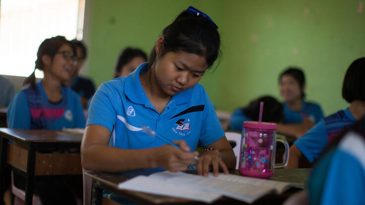 A girl studying at a school desk.