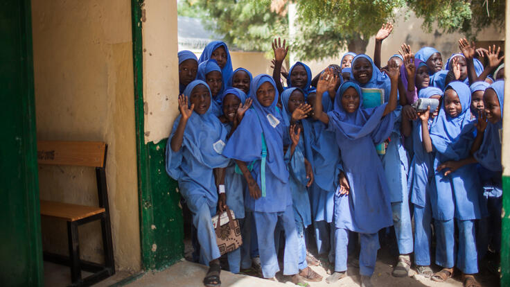 A group of women smiling and waving.