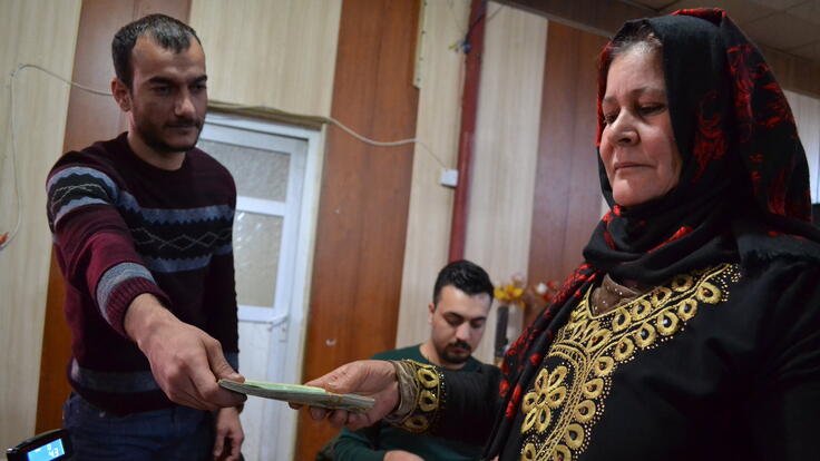 A man handing a woman paper.