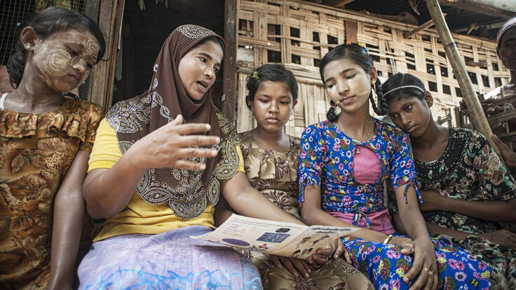 A group of people reading paper.