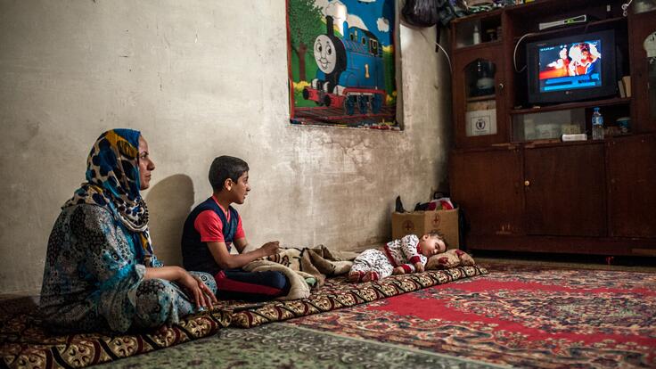 A mother and child watching tv together.