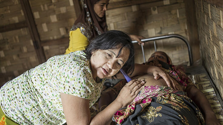 A clinic health worker giving an expectant mother a check-up.