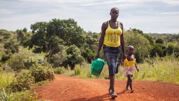 A South Sudanese woman and her daughter crossing the border into Uganda.