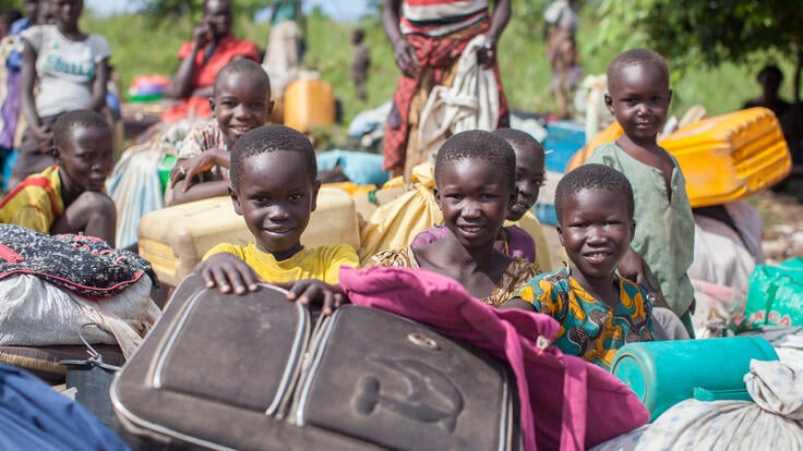 A group of children holding luggage bags.