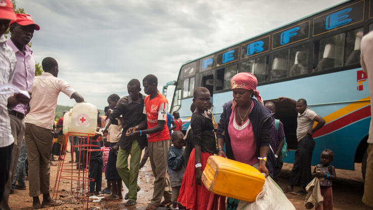 A group of people in front of a bus.