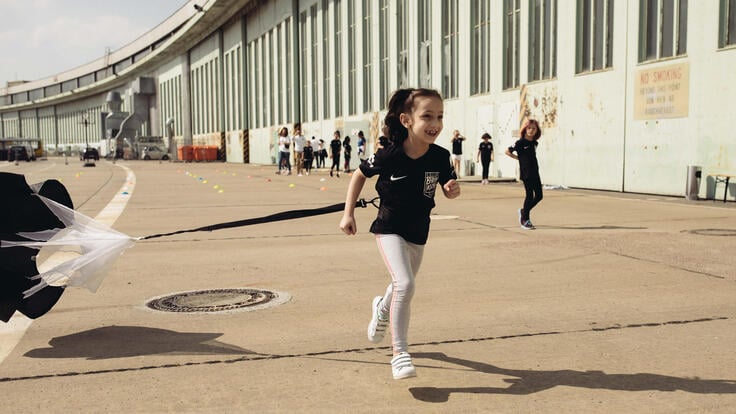 A girl running in the parachute race.