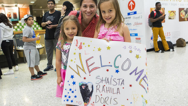 Family holding a welcome side.