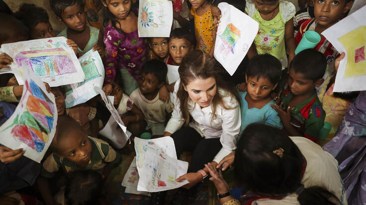 Children showing Queen Rania drawings they made.