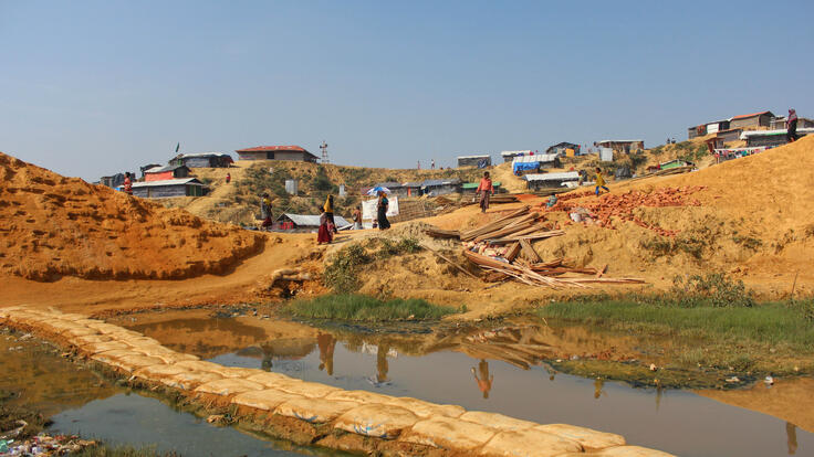 People walking across wet land.