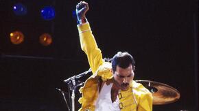 Freddie Mercury in performance, pumping his fist in the air
