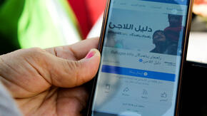 The Refugee.Info website shown on a mobile phone