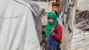 Syrian girl stands in front of her uncle’s tent in Idlib countryside
