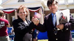 Two refugees hold an American flag at a citizenship ceremony. 