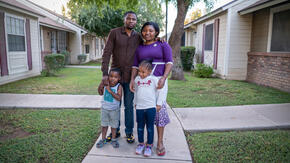 Robert, Edith and their young daughter and son stand for a photo on the sidewalk outside their home in Arizona