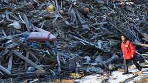 A Japanese aid worker walks through the debris of ruined buildings near the city of Kamaishi.