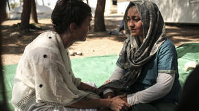 Lena Headey, who plays Cersei Lannister on Game of Thrones, talks with Afghan refugee Rehanna, age 27, holding her hands