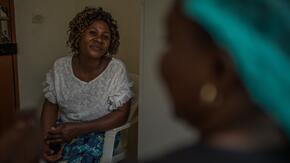 An Ebola survivor in Congo receives mental health support from International Rescue Committee staff member seated across from her.