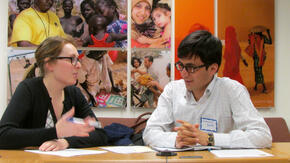 IRC Volunteer coaches a client from Afghanistan at a resume writing workshop.