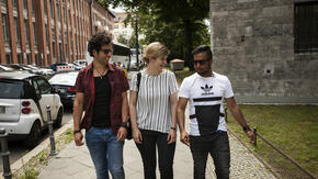 And IRC aid worker walks with two men living as refugees in Germany