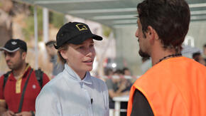 Piper Perabo speaks with a refugee in Greece