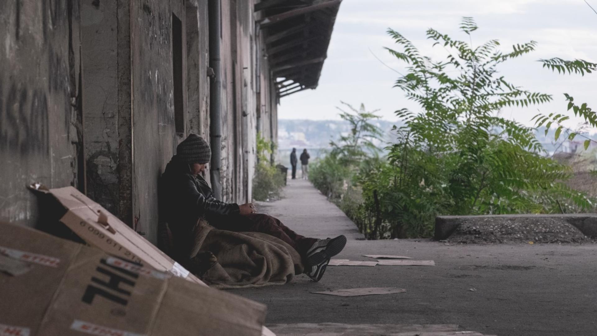 A young Afghan is one of hundreds of refugees living in a disused warehouse near the central bus station in Belgrade, Serbia. A young Afghan refugee sits huddled outside an abandoned warehouse in Serbia.