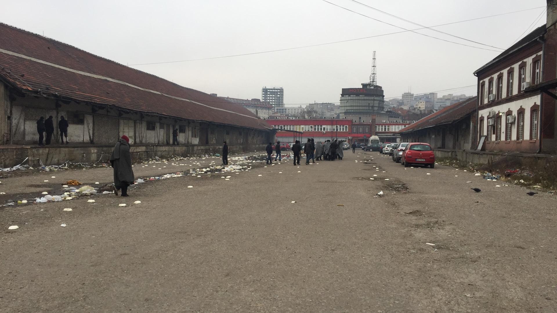 Refugees wrapped in blankets gather outside an abandoned warehouse near the bus station in Belgrade, Serbia. 