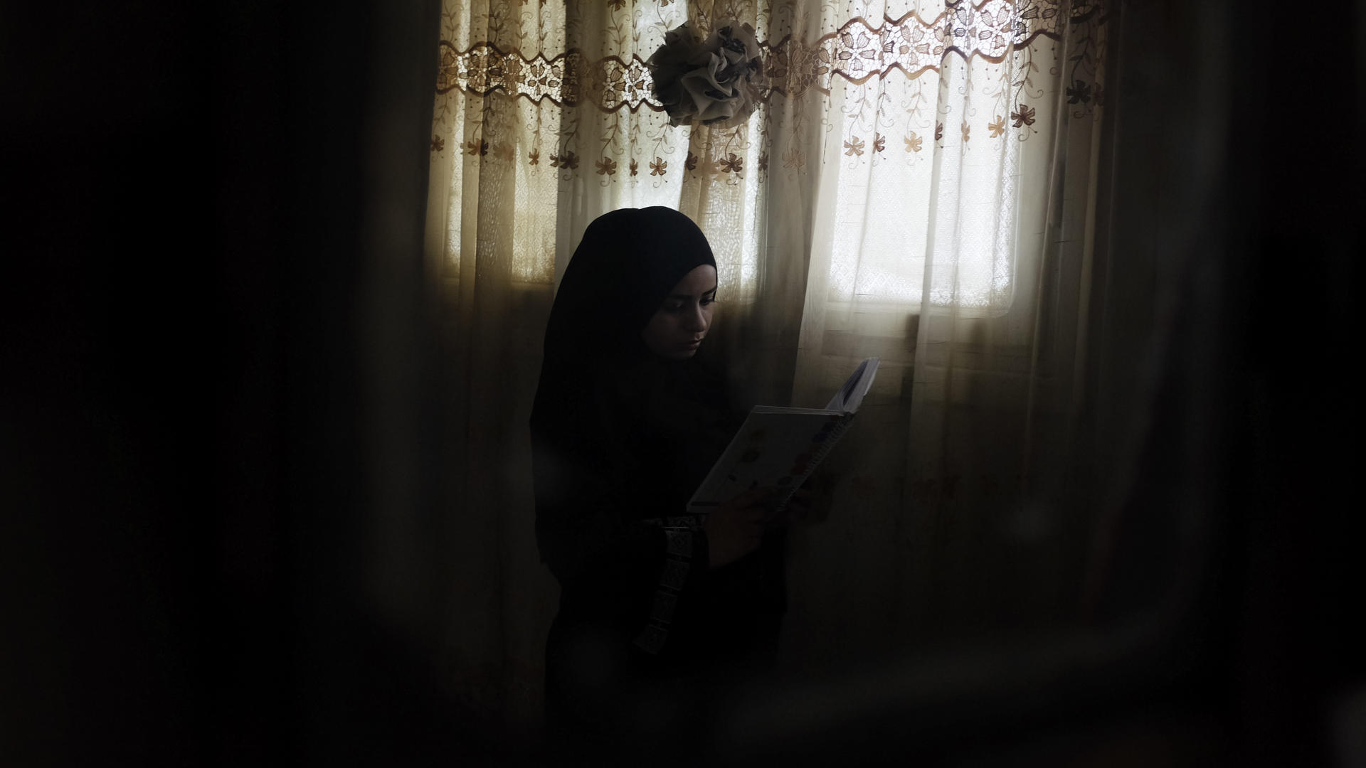 Rawan in Jordan Rawan sits by a window, reading