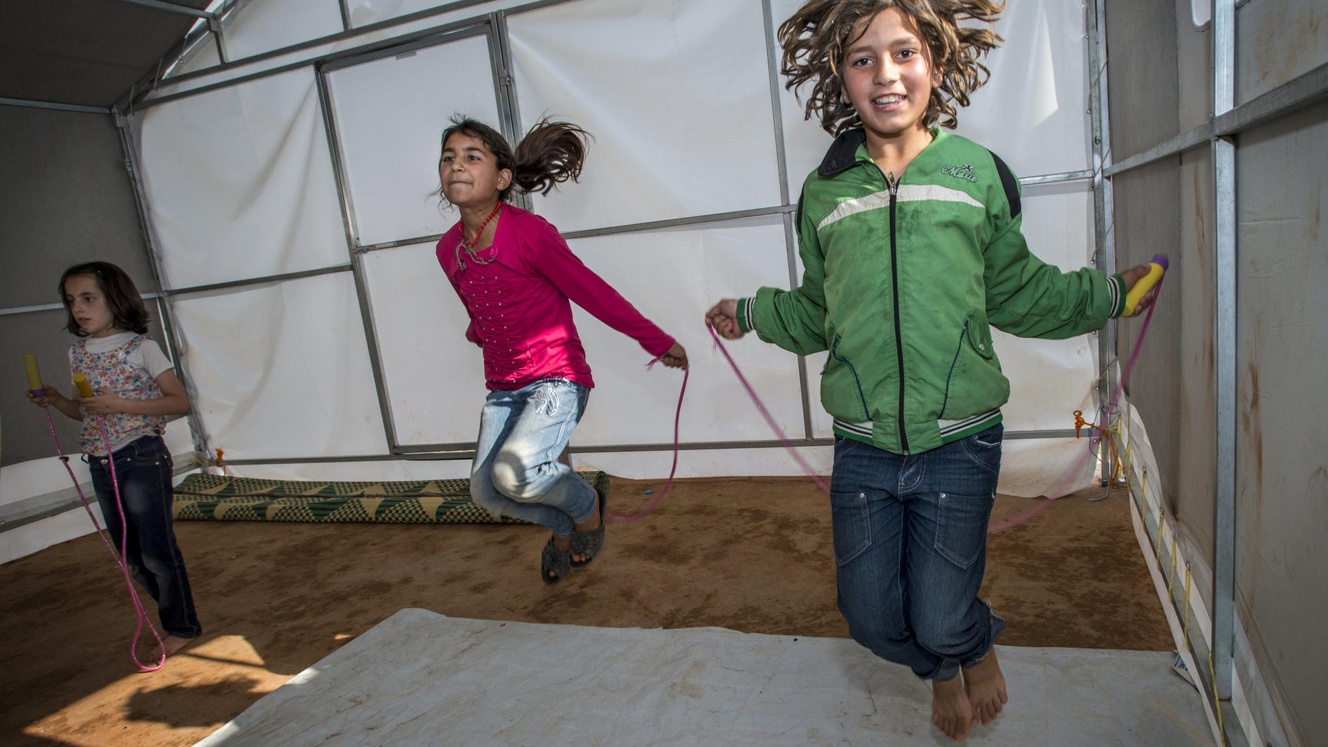 Girls jump rope in Idlib, Syria Two girls jump rope in a temporary classroom in Idlib.