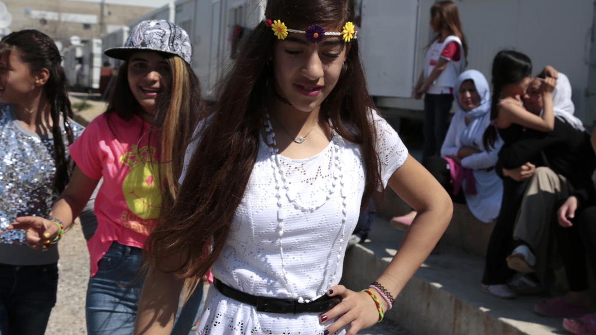 Nazia and Rolian met in a refugee camp near Athens, Greece. They share a love of dance. Nazia and Rolian dance outside at Elonas refugee camp.