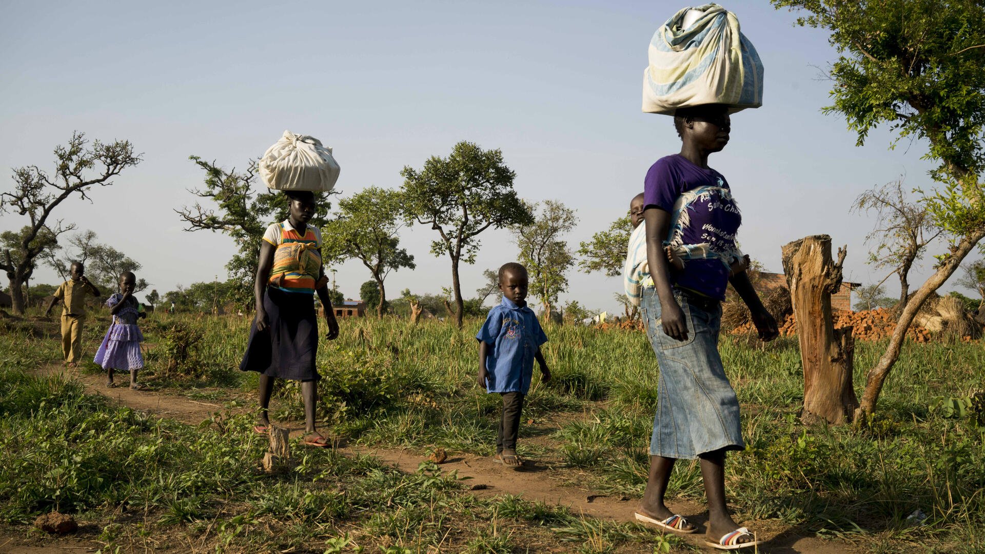 Women and their children arrive from Yei, South Sudan on foot, into the border town of Bosia,