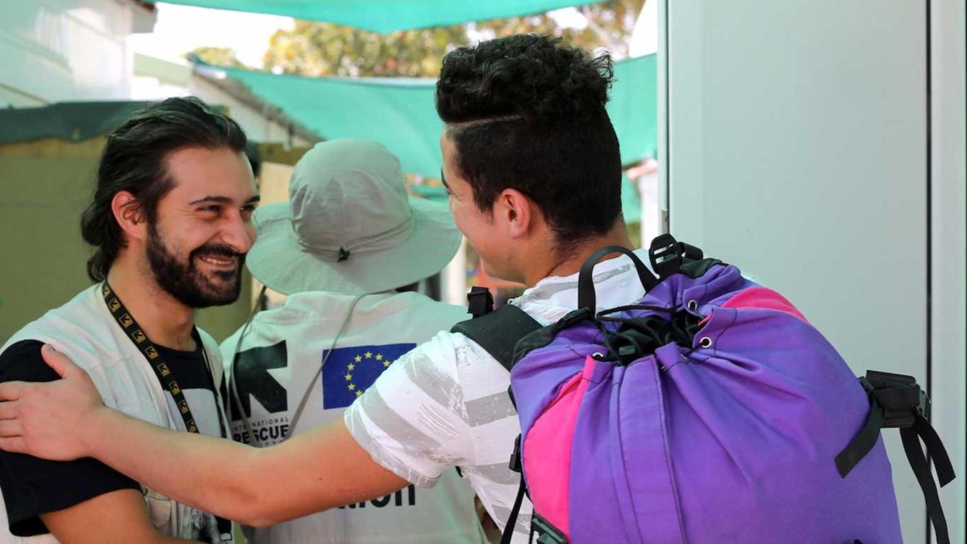 A young refugee in Greece says goodbye to an IRC aid worker as he leaves the camp to be reunited with relatives.