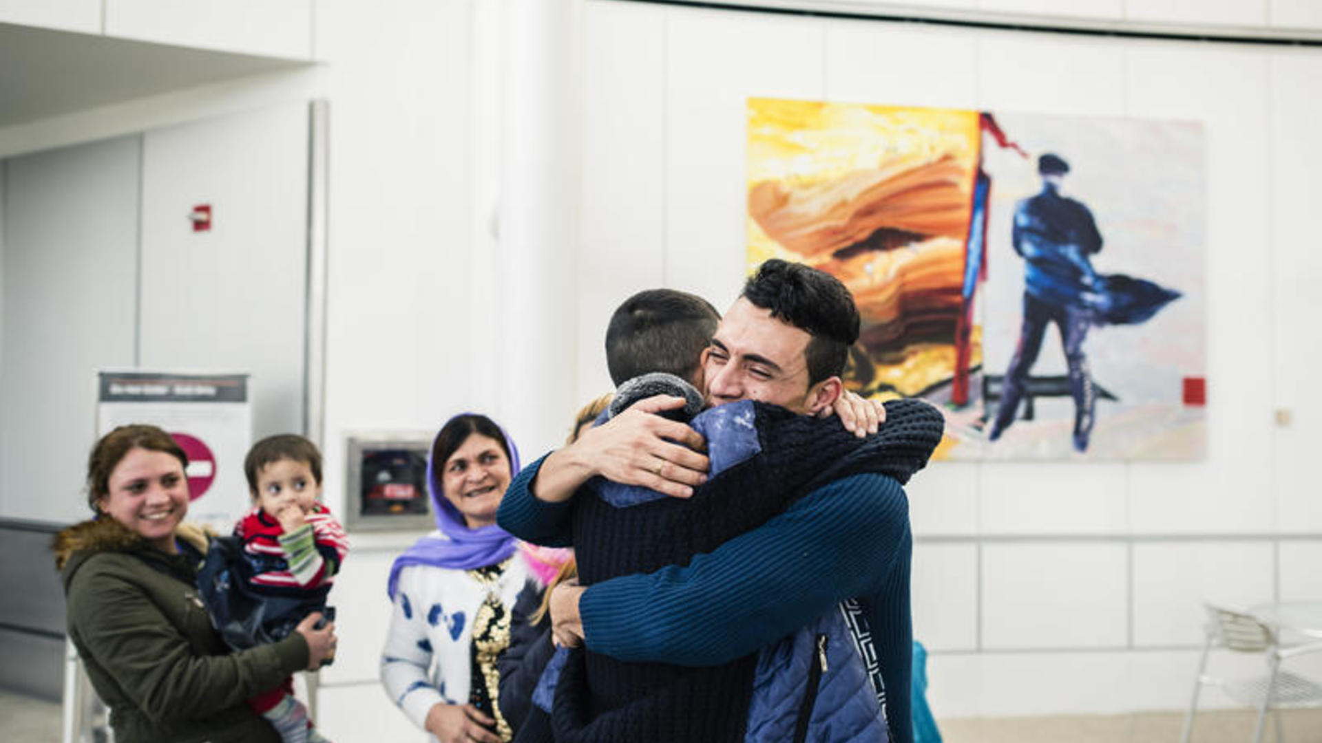 An Iraqi refugee hugs one of his relatives on arrival at a U.S. airport after being vetted for resettlement