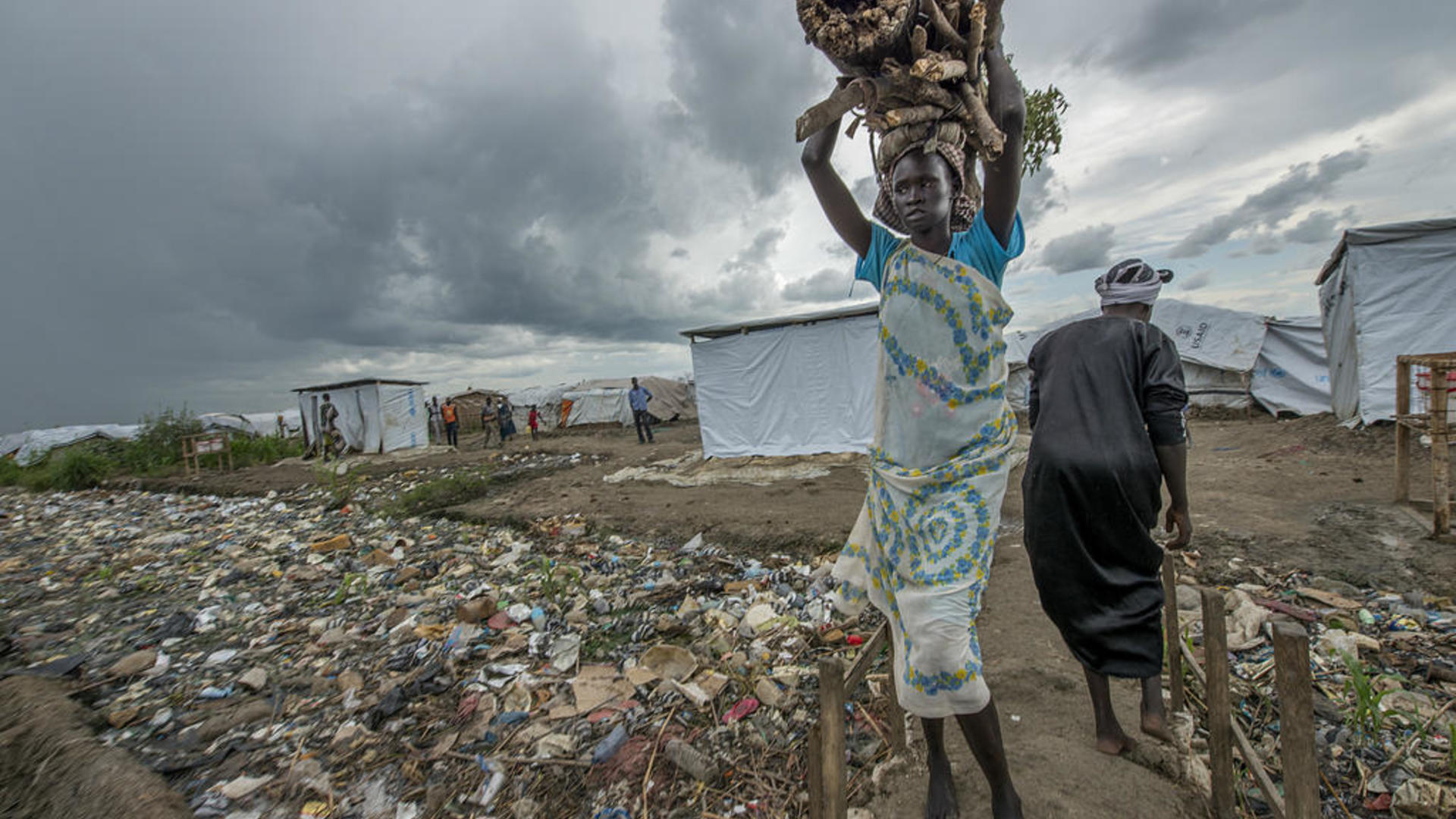 A woman carries firewood on her head in a camp for displaced people in South Sudan