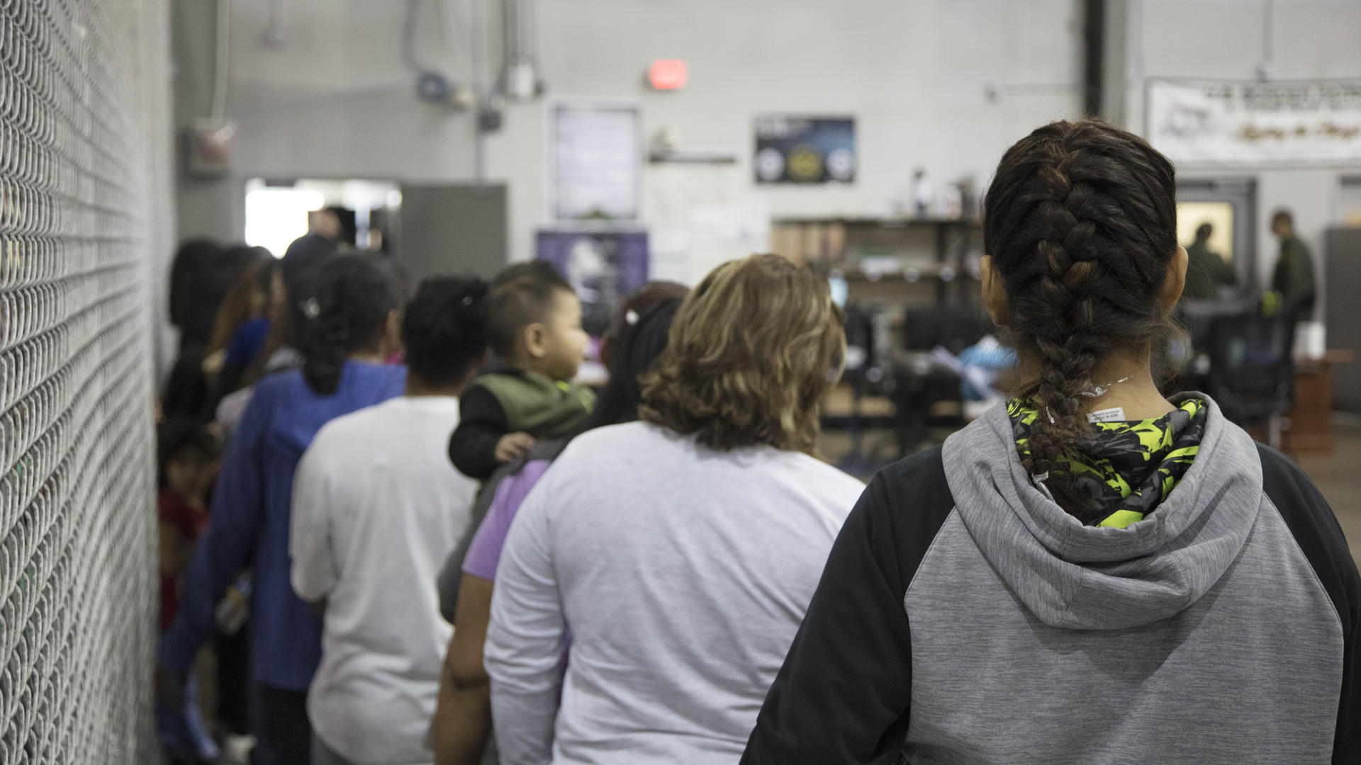 U.S. Border Patrol agents conduct intake of border crossers at the Central Processing Center in McAllen, Texas, Sunday, June 17, 2018. Photo: U.S. Customs and Border Patrol Women and children wait in line to be processed at a U.S. Border Patrol facility in Texas