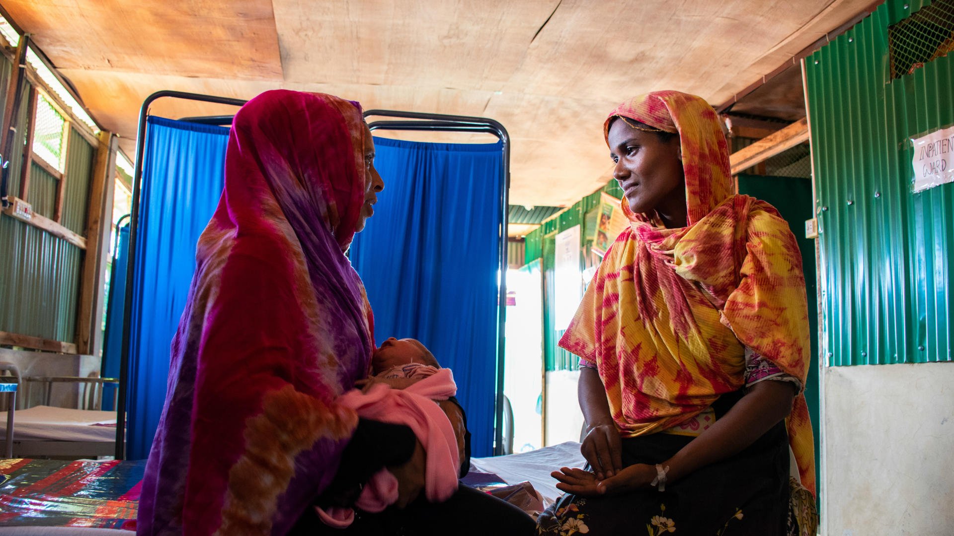Fatima visits Shahera and her newborn at the women's health center in Kutupalong refugee camp. 