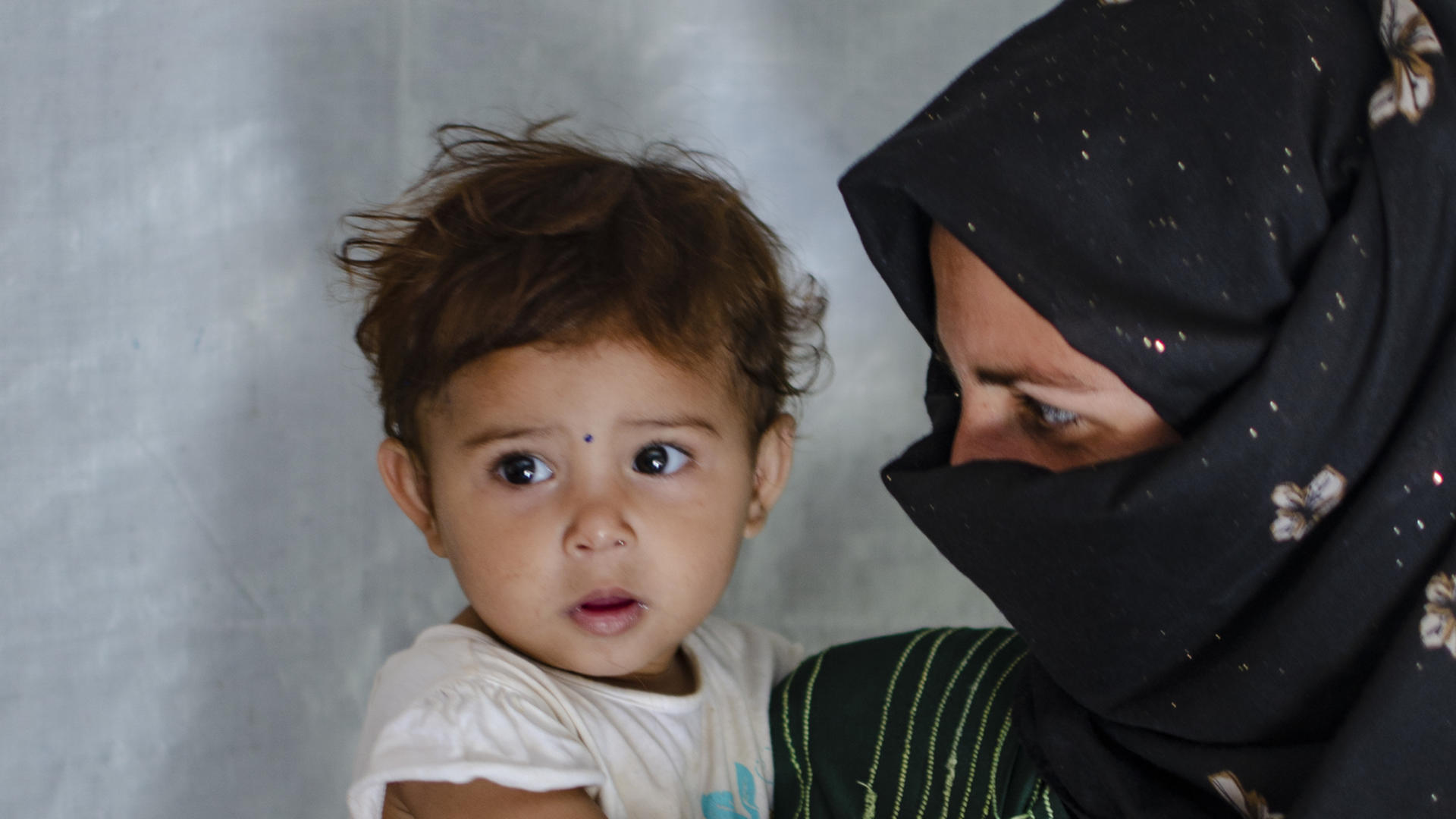 Syrian refugee with her baby daughter at a tented settlement in Lebanon