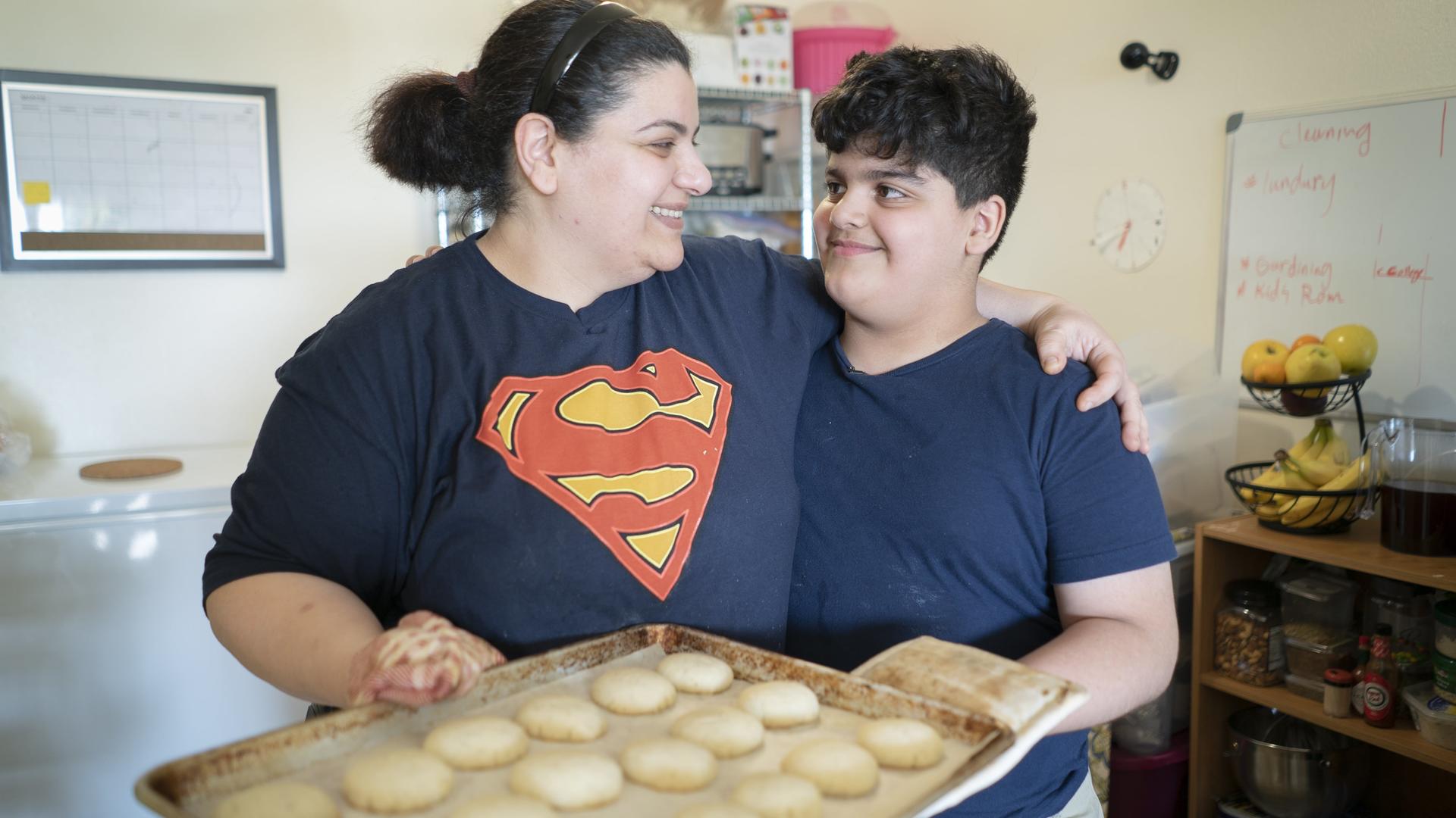10-year-old Yousif holds a plate of shakar lama cookies with his mom, Taghreed